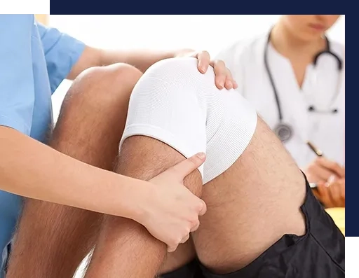 A person is holding his knee while another person looks on.