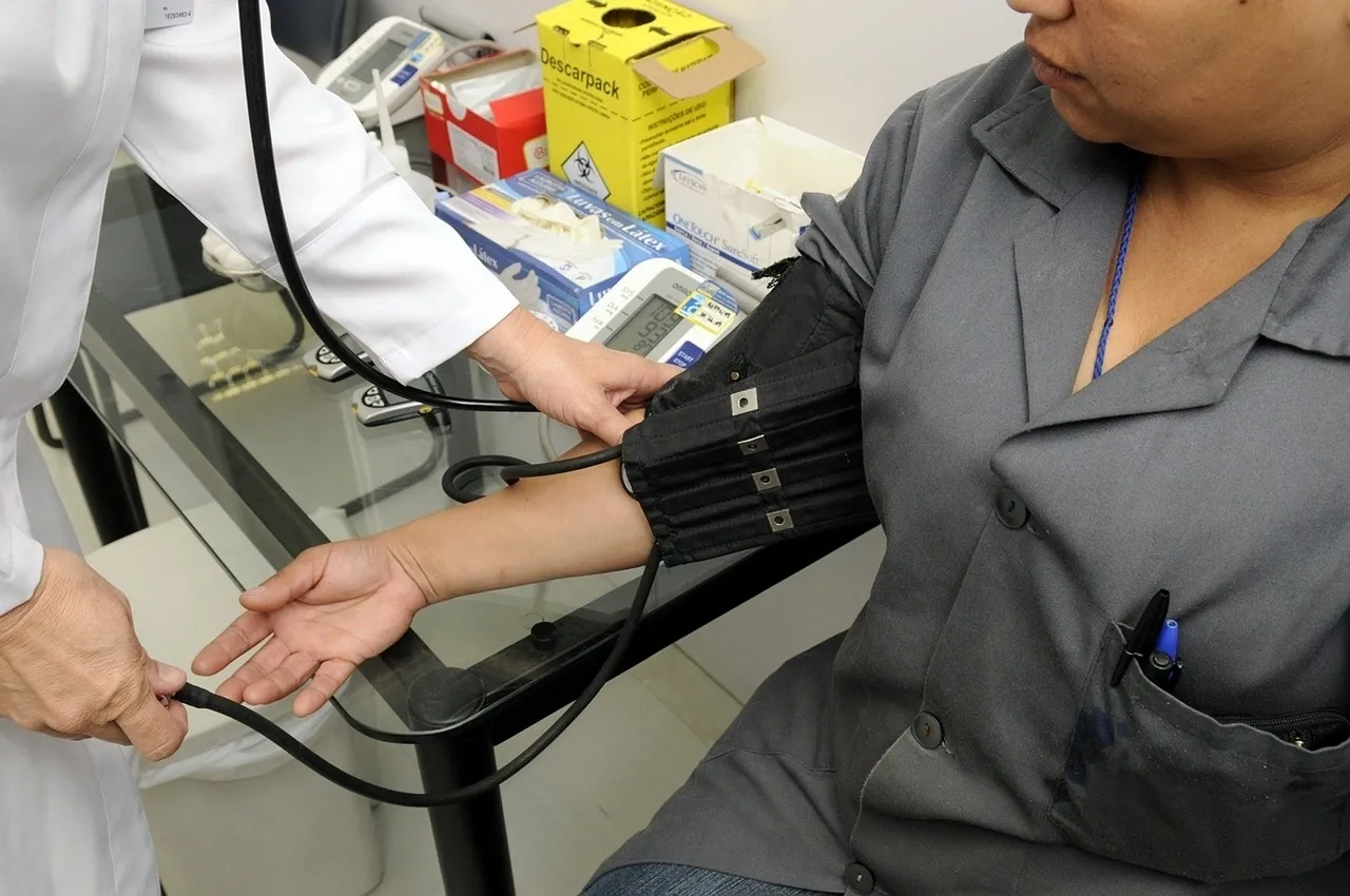 A person is taking blood pressure at the doctor 's office.